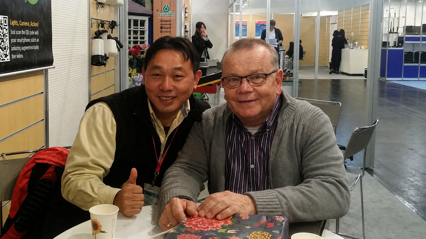 Two industry professionals during a market visit in front of a product display